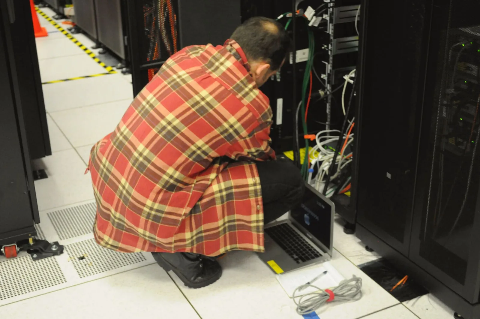 Technician working with a laptop at a server rack